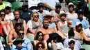 Sejumlah pria membuka bajunya saat menyaksikan pertandingan putaran tunggal putra antara petenis Bulgaria Grigor Dimitrov dan petenis Austria Dennis Novak pada hari pertama turnamen tenis Australia Terbuka di Melbourne (15/1). (AFP Photo/Greg Wood)