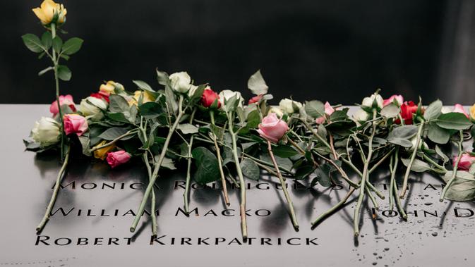 Mawar diletakkan atas plakat bertuliskan nama-nama korban pengeboman World Trade Center 1993 pada upacara peringatan di New York, Rabu (26/2/2020). 27 tahun lalu teroris meledakkan bom di sebuah garasi parkir WTC yang menewaskan enam korban. (Scott Heins/Getty Images/AFP)