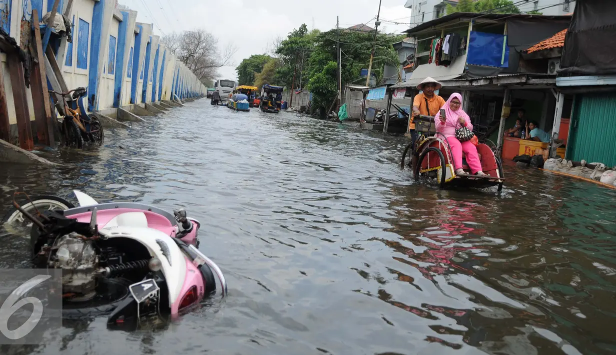 Warga melintasi banjir dengan menumpang becak di Kawasan Muara Angke, Jakarta, Rabu (11/1). Banjir rob setiap laut pasang ini terjadi setelah tanggul laut jebol pada pertengahan tahun lalu. (Liputan6.com/Gempur M. Surya)