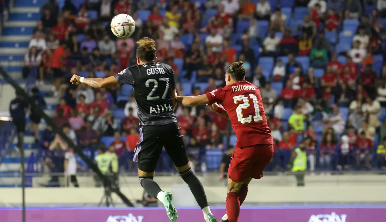 <p>Bek Lyon, Malo Gusto (Kiri) melompat untuk melakukan sundulan saat dikawal oleh bek Liverpool, Kostas Tsimikas selama pertandingan Dubai Super Cup 2022 di Al Maktoum Stadium, Uni Emirat Arab, Minggu (11/12/2022). Lyon menang atas Liverpool 3-1. (AFP/Karim Sahib)</p>