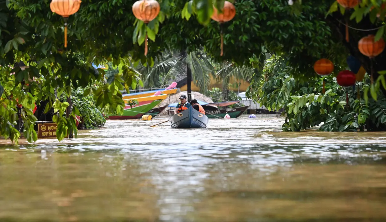 Orang-orang menyusuri jalan yang terendam banjir dengan perahu setelah hujan deras di Hoi An pada Kamis 30 Oktober 2025. Provinsi-provinsi pesisir Vietnam telah dilanda hujan deras sejak 26 Oktober 2025, dengan rekor curah hujan hingga 1,7 meter (lima kaki tujuh inci) dalam 24 jam terakhir. (NHAC NGUYEN/AFP)
