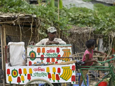 Pengungsi Rohingya menjual es krim di kamp pengungsi Jamtoli, Ukhia (22/3/2022). Ratusan ribu orang Rohingya melarikan diri dari Myanmar yang mayoritas beragama Buddha setelah tindakan keras tahun 2017, yang menjadi subjek kasus genosida di pengadilan tertinggi PBB di Den Haag. (AFP/Munir Uz Zaman)