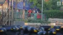 Dua orang pria melihat bentrok antara polisi dan massa aksi di kawasan Tanah Abang, Jakarta, Rabu (22/5/2019).  Beberapa kelompok massa menggunakan benda-benda keras hingga mercon untuk menahan laju petugas keamanan. (Liputan6.com/Herman Zakharia)