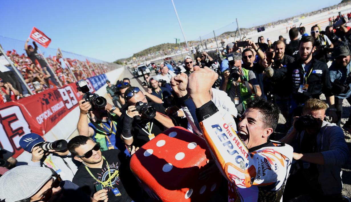 Marc Marquez (kanan) merayakan keberhasilan meraih gelar juara dunia MotoGP 2017 bersama fans pada balapan MotoGP Valencia di Ricardo Tormo Circuit, Cheste, (12/11/2017). Gelar tersebut merupakan yang keempat buat Marquez.  (AFP/Jose Jordan)