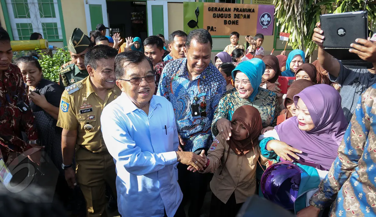 Sejumlah siswa dan guru berdesakan untuk bisa berjabat tangan dengan Wapres Jusuf Kalla saat mengunjungi SDN 2 Manurunge, Bone, Makassar, Sabtu (6/6/2015). (Liputan6.com/Faizal Fanani) 