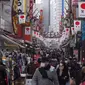 Orang-orang membeli makanan dan perlengkapan untuk merayakan Tahun Baru di distrik perbelanjaan Ueno di Tokyo, Selasa (29/12/2020). Tokyo melaporkan peningkatan kasus virus corona menjelang musim libur tahun baru, dimana biasanya masyarakat yang tinggal di ibu kota akan mudik. (Kazuhiro NOGI/AFP)
