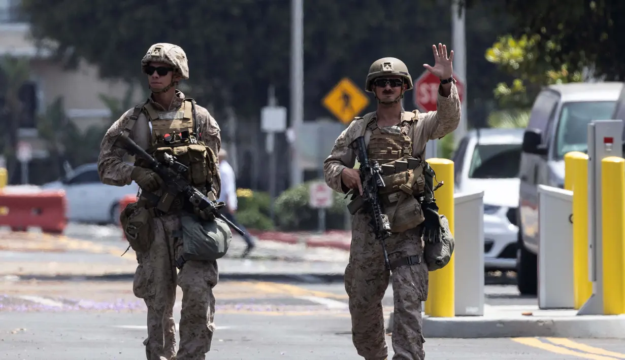 Marinir Amerika Serikat (AS) berjalan di tempat parkir Gedung Federal Wilshire di Los Angeles, California, pada 13 Juni 2025. (ETIENNE LAURENT/AFP)