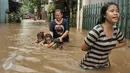 Warga melintasi banjir di kawasan Cipinang Melayu, Jakarta Timur, Senin (20/2). Banjir ini merendam RW 3 hingga RW 4, Kelurahan Cipinang Melayu, Kecamatan Cipinang Muara. (Liputan6.com/Yoppy Renato)