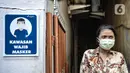 Warga saat berada di dekat papan imbauan mengenakan masker di Kampung Sehat, Utan Kayu Selatan, Jakarta, Rabu (11/11/2020). (merdeka.com/Iqbal S. Nugroho)