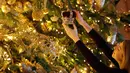 Replika mahkota dipasang pada pohon cemara besar dari Windsor Great Park di ujung aula St. George di Windsor Castle, 30 November 2018. Pohon setinggi 6 meter itu dihias dengan pernak-pernik Natal berwarna emas serta ornamen kerajaan.  (AP/Frank Augstein)