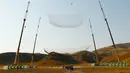 Skydiver, Luke Aikins bersiap mendarat di sebuah jaring raksasa setelah terjun bebas dari pesawat di atas ketinggian 25.000 kaki tanpa menggunakan parasut dan wingsuit, di Simi Valley, California, Sabtu (30/7). (Mark Davis/Getty Images for Stride Gum/AFP)