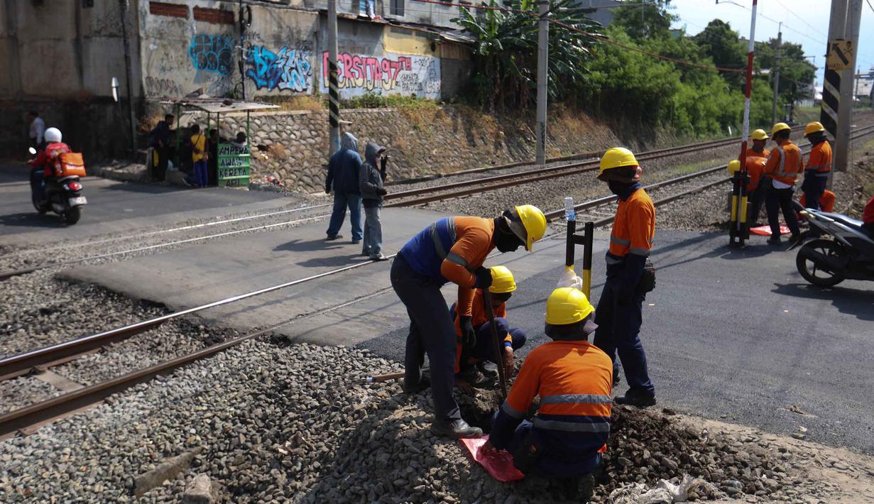 Langkah ini diambil sebagai respons setelah terjadinya insiden kecelakaan antara Kereta Api Jarak Jauh (KAJJ) Argo Bromo Anggrek dan Kereta Rel Listrik (KRL) Commuter Line di Stasiun Bekasi Timur pada Senin 27 April 2026 malam. Tampak dalam foto, aktivitas pekerja dari PT Kereta Api Indonesia (KAI) Daop 1 Jakarta saat proses pemasangan palang pintu di perlintasan sebidang Jalan Ampera, dekat Stasiun Bekasi Timur, Bekasi, Jawa Barat. (Kapanlagi.com/Budy Santoso)