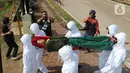 Petugas Satpol PP Kabupaten Bogor yang mengenakan pakaian hazmat menggotong warga pelanggar PSBB di kawasan Stadion Pakansari, Kabupaten Bogor, Jawa Barat, Minggu (6/9/2020). Pemkab Bogor menerapkan sanksi denda Rp 100 ribu serta sanksi sosial bagi pelanggar PSBB. (Liputan6.com/Herman Zakharia)