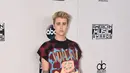 Busana yang dikenakan Justin Bieber kurang pantas dikenakan untuk ajang musik bergengsi American Music Awards. Ia terlihat kurang berkelas dalam kaos kebesaran dan celana jeans robek. (AFP/Bintang.com)