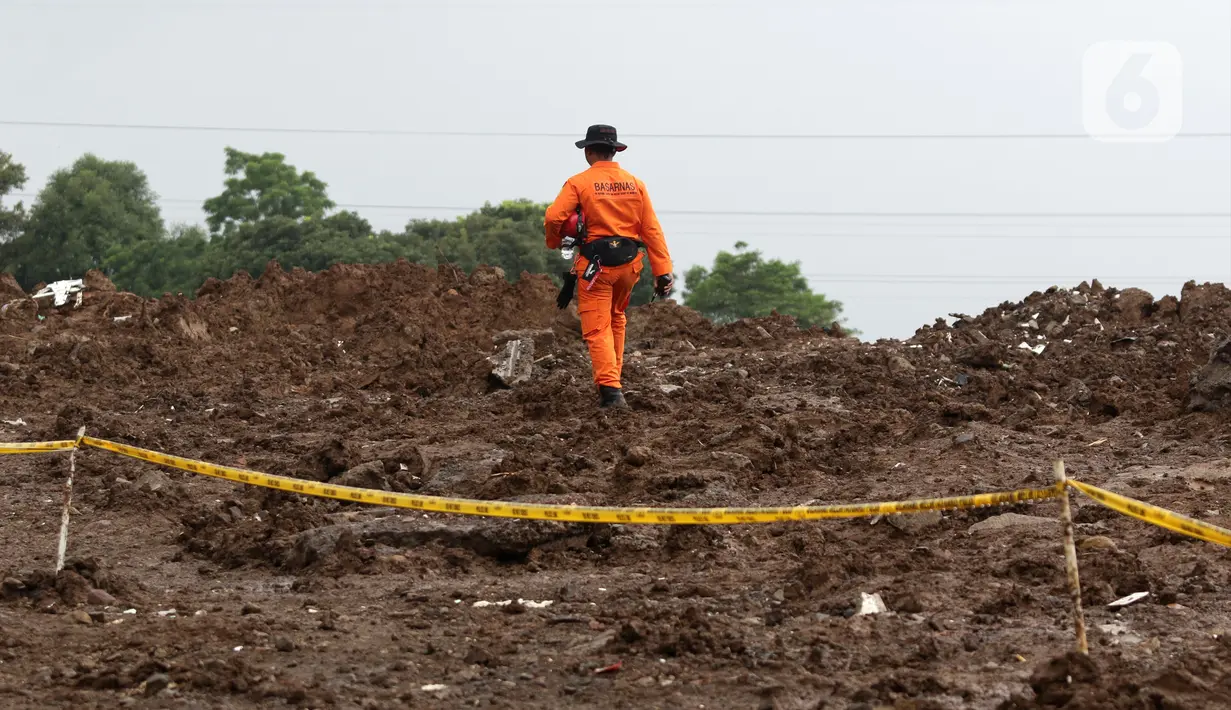Tim SAR berusaha mencari sisa korban tanah longsor akibat gempa Cianjur di kawasan Cugenang, Kabupaten Cianjur Jawa Barat, Jumat (25/11/2022). Upaya pencarian korban terpaksa dihentikan sementara akibat hujan. (Liputan6.com/Helmi Fithriansyah)