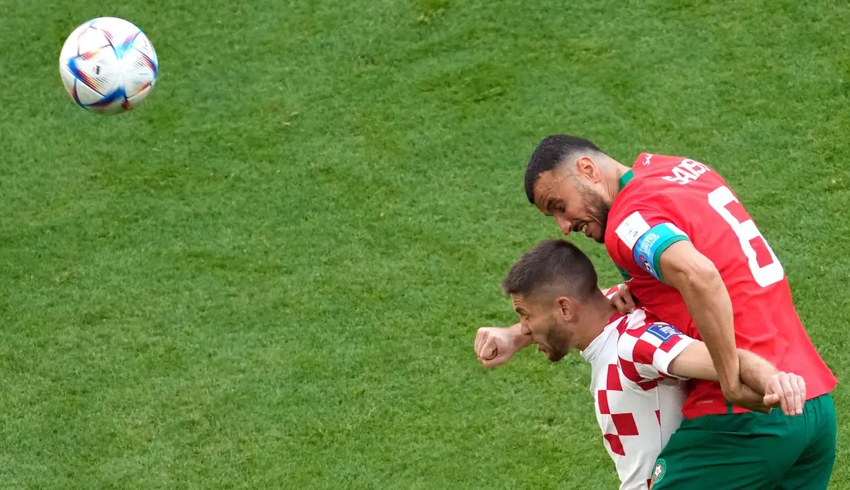 Pemain Kroasia Andrej Kramaric (kiri) dan pemain Maroko Romain Saiss melakukan sundulan pada pertandingan sepak bola Grup F Piala Dunia 2022 di Stadion Al Bayt, Al Khor, Qatar, Rabu (23/11/2022). Pertandingan berakhir imbang dengan skor 0-0. (AP Photo/Darko Vojinovic)