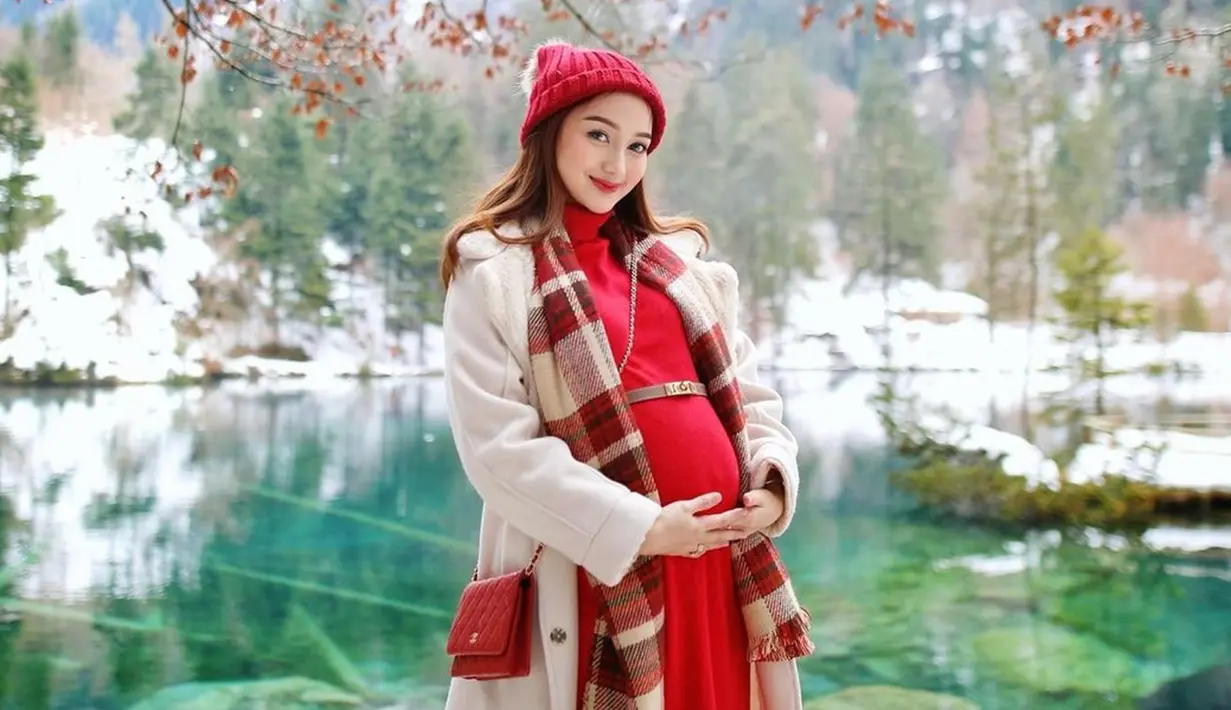 Tampil serba merah saat nikmati keindahan Blausee, Swiss, Nanda Arsyinta tampil menawan. Kupluk yang dikenakannya tak hanya untuk fashion tetapi juga menghangatkan kepala dan telinganya dari dinginnya udara Swiss. Terlihat simpel dengan dress dan blazer, namun OOTD Nanda ini ramai dipuji. (Liputan6.com/IG/@nandaarsynt)