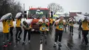 Peserta wanita membawa karung berisi batu bara saat mengikuti World Coal Carrying Championships di Desa Gawthorpe, Wakefield, Inggris Utara, Senin (2/4). Kompetisi  tahunan mengakut karung batu bara ini dalam memperingati Senin Paskah. (OLI SCARFF/AFP)