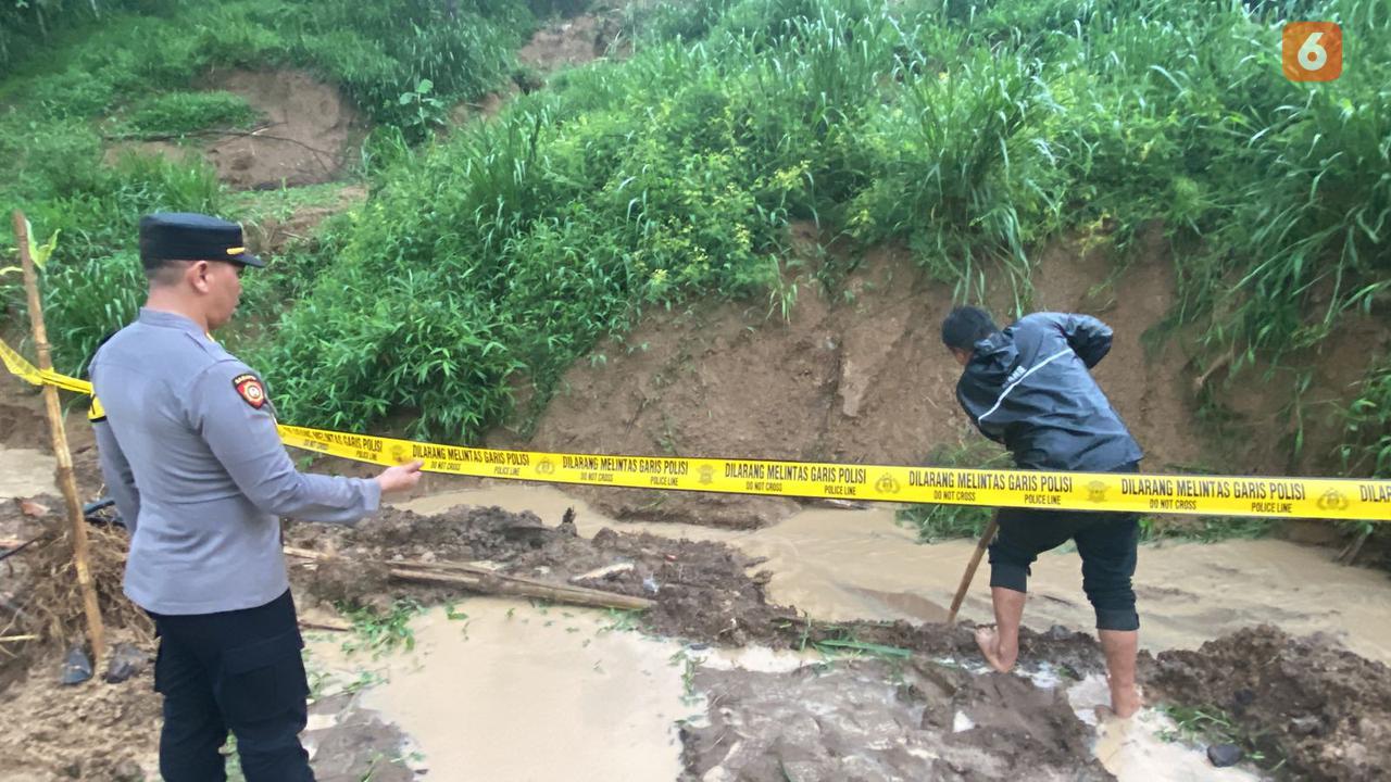 Petugas Polsek Nyalindung memberi garis polisi di lokasi kejadian yang menewaskan 3 balita akibat tenggelam di Kabuoaten Sukabumi (Liputan6.com/Fira Syahrin).
