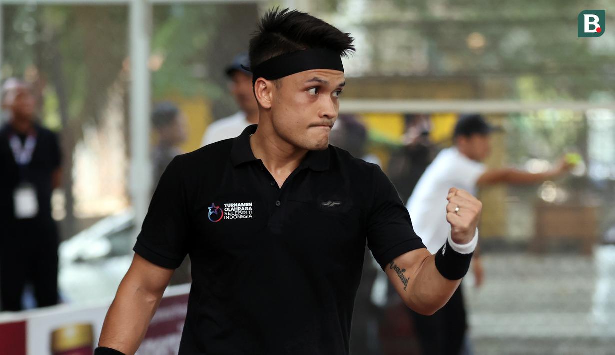 Ekspresi artis yang sekaligus atlet MMA, Randy Pangalila, saat meraih poin atas lawannya, Rezky Aditya, dalam pertandingan tenis tunggal putra Turnamen Olahraga Selebriti Indonesia yang berlangsung di Gelanggang Olahraga UNJ, Rawamangun, Jakarta Timur, Sabtu (29/7/2023). Pertandingan kali ini berhasil dimenangkan oleh Rezky Aditya dengan dua set langsung (1-6 - 1-6). (Bola.com/Abdul Aziz)