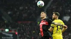 Gelandang Bayer Leverkusen #34 Granit Xhaka (kiri) berebut bola dengan penyerang Borussia Dortmund #14 Niclas Fuellkrug pada spieltag ke-12 Bundesliga 2023-24 di Bay Arena, Minggu (3/12/2023) malam WIB.
(INA FASSBENDER / AFP)