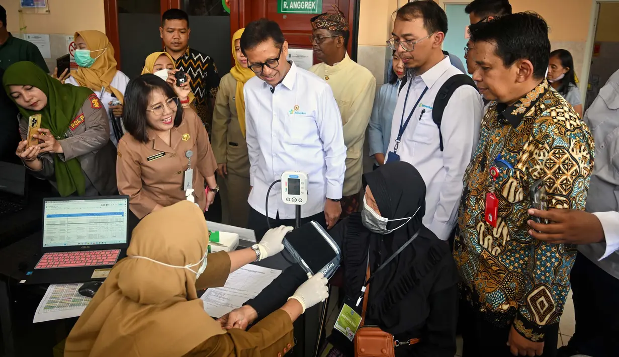 Menteri Kesehatan, Budi Gunadi Sadikin (tengah) berbincang dengan masyarakat di sebuah puskesmas pada hari pertama program Pemeriksaan Kesehatan Gratis (PKG) di Surabaya, Jawa Timur pada 10 Februari 2025. (JUNI KRISWANTO/AFP)