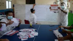 Petugas KPPS melakukan penghitungan suara di TPS 36 Perumahan Griya Pamulang 2, Tangerang Selatan, Rabu (9/12/2020). Sebanyak 976.019 orang terdaftar dalam Daftar Pemilih Tetap (DPT) pada Pilkada Tangsel 2020 yang diikuti tiga pasang calon Wali Kota dan Wakil Wali Kota (merdeka.com/Dwi Narwoko)