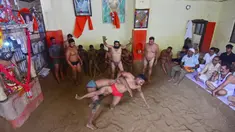 Pegulat beraksi dalam pertandingan gulat tradisional di klub gulat Loknath Vyayamsala di Prayagraj, India, (21/8/2023). Acara tersebut untuk merayakan festival Hindu Nag Panchami. (AFP/Sanjay kanojia)