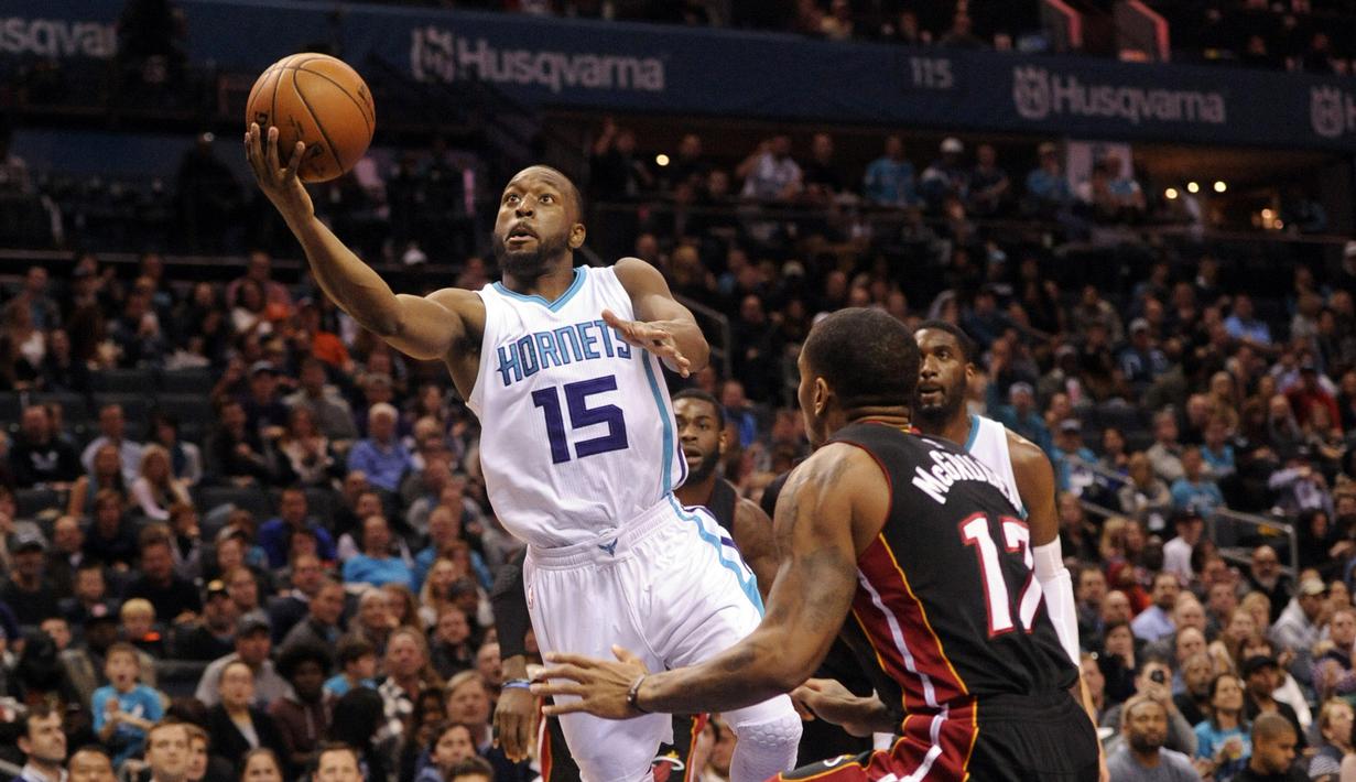 DePemain Charlotte Hornets, Kemba Walker #15 mencoba melakukan layup saat dihadang pemain  Miami Heat,  Rodney McGruder #17 pada laga NBA di Spectrum Center, (29/12/2016). Hornets menang 91-82. (Reuters/Sam Sharpe-USA TODAY Sports)