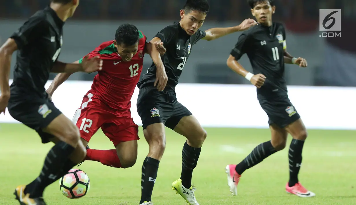 Pemain belakang Indonesia U-19, M Rifad Marasabessy (kedua kiri) mencoba lolos dari kawalan pemain Thailand U-19 pada laga persahabatan di Stadion Wibawa Mukti, Cikarang, Jawa Barat, Minggu (8/10). Indonesia menang 3-0. (Liputan6.com/Helmi Fithriansyah)