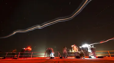 Foto dengan teknik long eksposur menunjukkan para fotografer bekerja dari atap gedung perakitan kendaraan saat roket SpaceX Falcon 9 dengan pesawat ruang angkasa Crew Dragon milik perusahaan tersebut mengosongkan bahan bakar sebelum peluncuran yang telah digosok dari pad 39A untuk misi Crew-6 di Kennedy Space Center NASA di Cape Canaveral, Florida, pada tanggal 27 Februari 2023. (CHANDAN KHANNA/AFP)