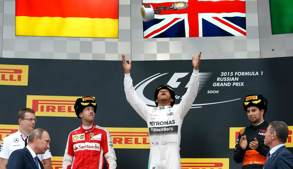 Pembalap Formula Satu (F1) tim Mercedes, Lewis Hamilton melempar trofi miliknya ke udara saat merayakan kemenangan usai ajang balap GP F1 Rusia di Sochi, Minggu (11/10). Lewis Hamilton berhasil memenangkan lomba Formula GP Rusia. (REUTERS/Grigory Dukor)