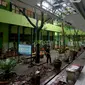 Pekerja membersihkan reruntuhan genting yang memenuhi halaman sekolah akibat gempa di SMK Negeri 1 Turen, Malang, Jawa Timur, Minggu (11/4/2021). Gempa yang mengguncang kawasan Malang dan sekitarnya membuat sejumlah bangunan rusak. (merdeka.com/Nanda F. Ibrahim)