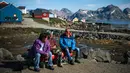 Penduduk mengobrol di Desa Kulusuk, Kota Sermersooq, Greenland, Denmark, 16 Agustus 2019. Sebagian besar penduduk Desa Kulusuk bekerja di sektor pariwisata dan perikanan lokal. (Jonathan NACKSTRAND/AFP)