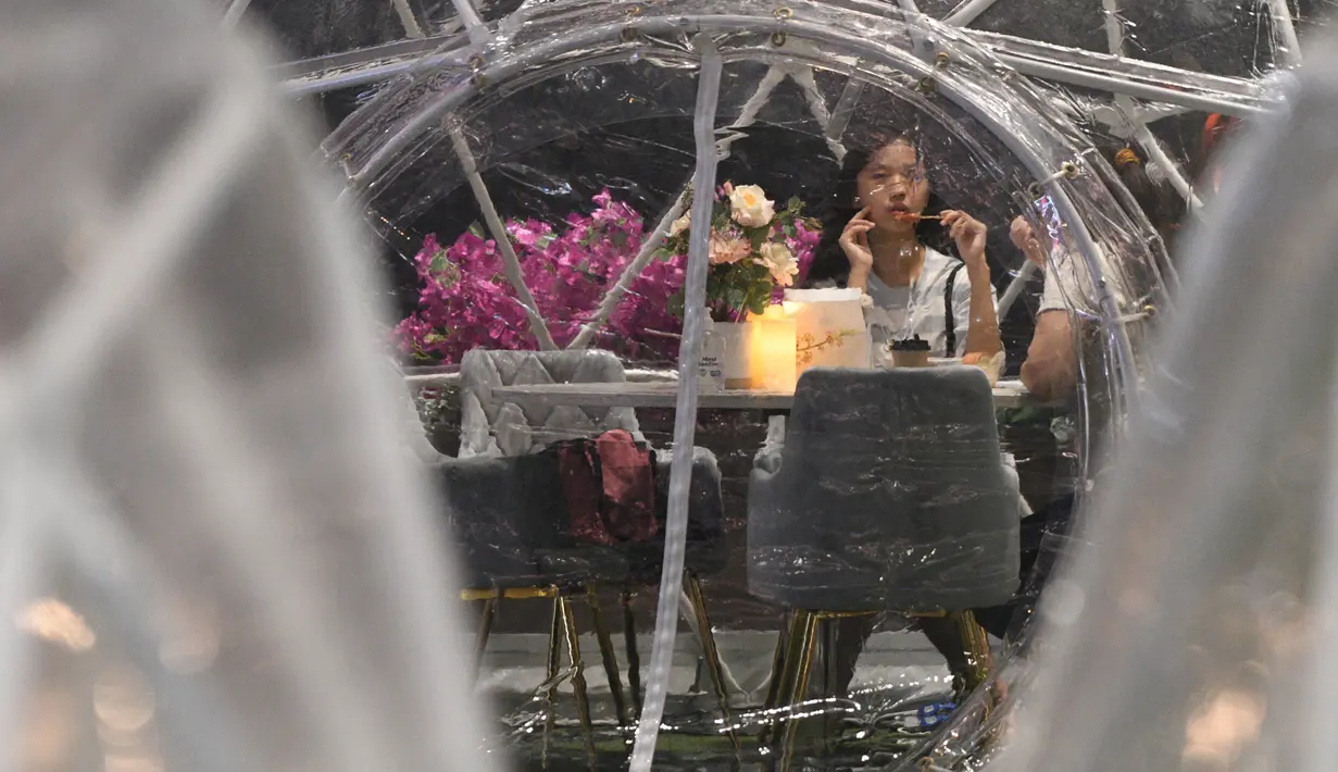 Orang-orang menyantap makanan dalam dining dome, instalasi tempat makan berbentuk kubah yang membantu mencegah penyebaran COVID-19, di Capitol Singapore Outdoor Plaza, Singapura, 21 Oktober 2020. (Xinhua/Then Chih Wey)