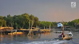Nelayan melintasi area permukaan air laut yang menyurut di sekitar pesisir Kamal Muara, Jakarta, Kamis (15/3). Fenomena turunnya permukaan air di daerah ini semakin menyulitkan akses nelayan untuk pergi melaut. (Merdeka.com/Iqbal S Nugroho)