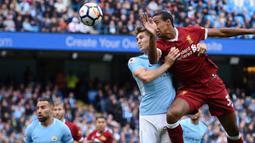 Bek Liverpool, Joel Matip, duel udara dengan bek Manchester City, John Stones, pada laga Premier League di Stadion Ettihad, Manchester, Sabtu (9/9/2017). City menang 5-0 atas Liverpool. (AFP/Oli Scarff)