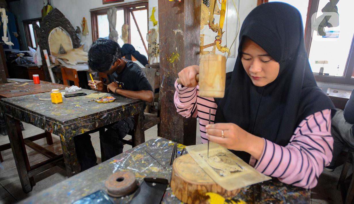 Mahasiswa Politeknik ATK Yogyakarta belajar membuat wayang kulit di Griya Ukir Kulit (Wayang) Sagio di kawasan Bantul, Yogyakarta, Senin (4/9/2023). (merdeka.com/Arie Basuki)