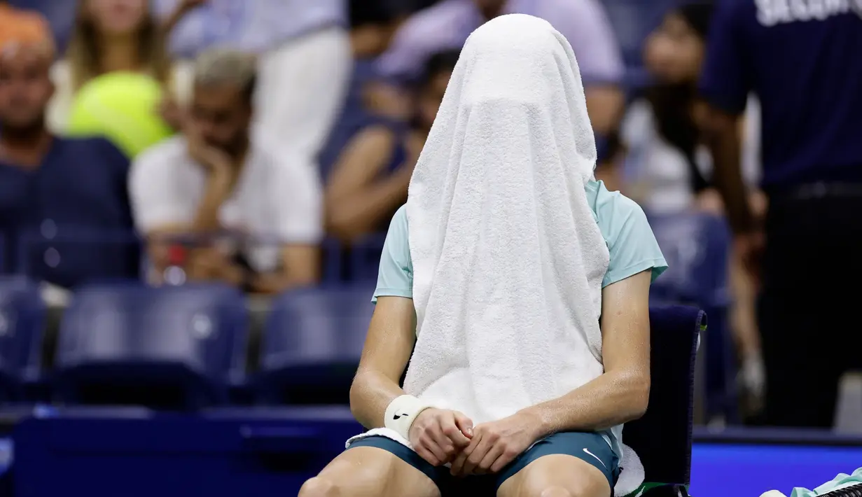 Petenis Italia Jannik Sinner menutupi wajahnya dengan handuk saat pertandingan putaran keempat melawan Alexander Zverev (Jerman) pada kejuaraan tenis AS Terbuka, Senin, 4 September 2023, di New York. (AP Photo/Adam Hunger)