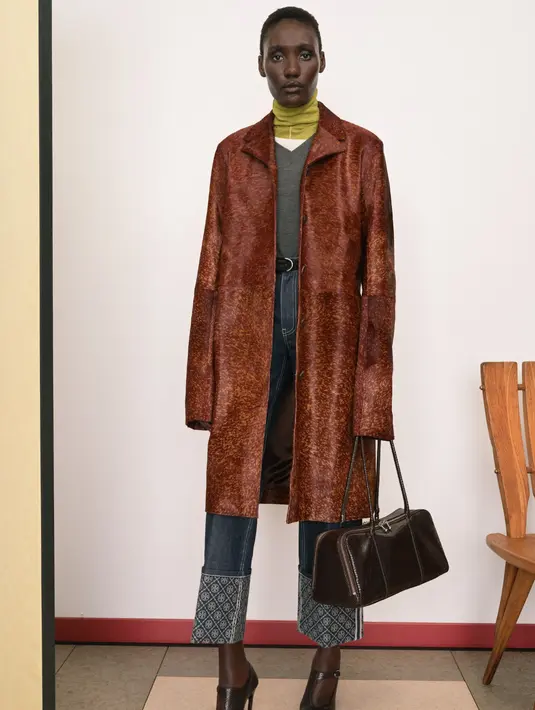 Pakaian model polo disulam dengan payet mikro yang dipilin; "flanel" kotak-kotak dibuat dari viscose yang cair; gaun kaos dililitkan dan diikat di sekeliling tubuh. Kerah disayat agar mudah dibuka, dan blus menjuntai di bahu seperti syal — gerakan persiapan yang benar-benar berubah. Pakaian kerja vintage yang ditemukan Tory di Jepang menginspirasi jaket lapangan yang menyusut dan detail utilitarian, seperti jahitan kontras dan panel yang diperkuat di bagian lutut celana panjang. Dok. Tory Burch