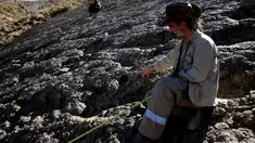 Paleontolog Sebastian Apesteguia mengukur jejak kaki dinosaurus yang ditemukan di Maragua, Bolivia (21/7). Jejak kaki dinosaurus diduga berusia 80 juta tahun tersebut berdiameter 1,2 meter. (REUTERS/ David Mercado)