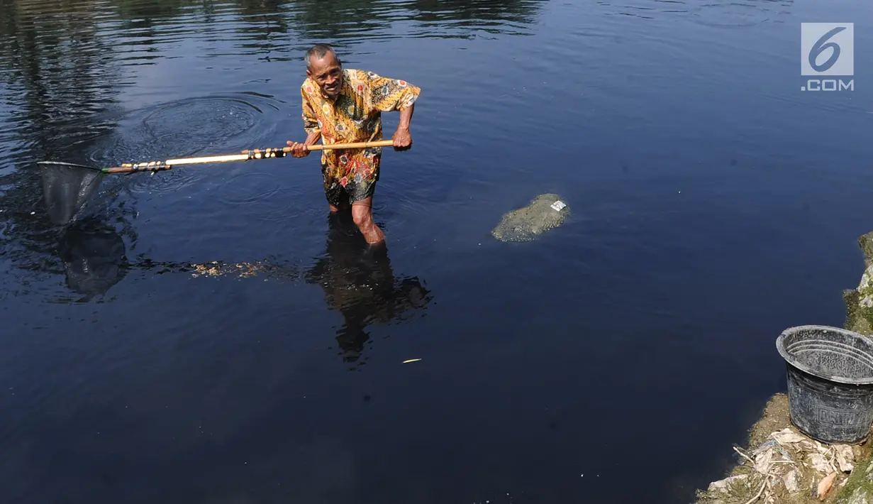 Warga mencari ikan di aliran Sungai Cileungsi yang berwarna hitam pekat di kawasan Bojong Kulur, Gunung Putri, Kabupaten Bogor, Jawa Barat, Selasa (23/7/2019). Air Sungai Cileungsi berubah warna menjadi hitam diduga akibat pencemaran limbah pabrik di kawasan tersebut. (merdeka.com/Arie Basuki)
