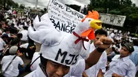 Demonstran memakai aksesoris berbentuk ayam saat unjuk rasa depan Istana Merdeka, Jakarta, (1/3). Dalam aksinya mereka membawa 1 truk ternak ayam untuk menyampaikan rasa kecewa terhadap turunnya Harga Pokok Produksi (HPP). (Liputan6.com/Faizal Fanani) 