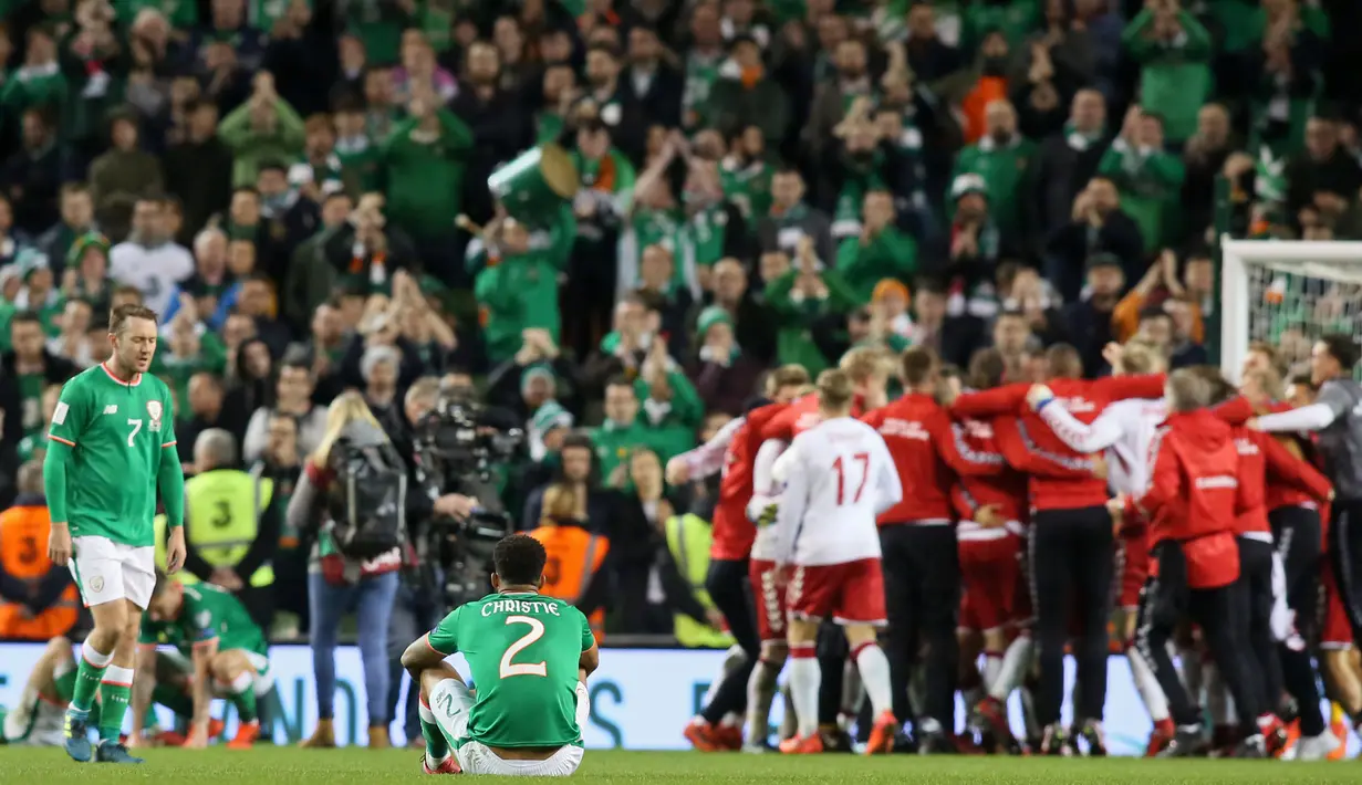Pemain Republik Irlandia bereaksi ketika pemain Denmark merayakan kemenangan mereka pada partai kedua play-off zona Eropa di Stadion Aviva, Rabu (15/11). Denmark melaju ke putaran final Piala Dunia 2018 usai menang 5-1. (Paul FAITH / AFP)