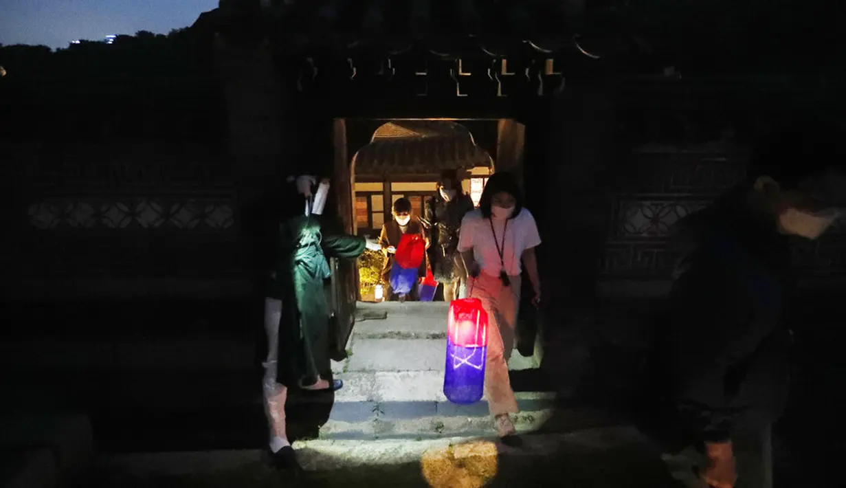 Pengunjung yang memegang lentera tradisional Korea berjalan-jalan selama Tur Cahaya Bulan di tengah pandemi virus corona COVID-19 di Istana Changdeokgung, Seoul, Korea Selatan, Kamis (13/5/2021). Istana Changdeok adalah istana Dinasti Joseon. (AP Photo/Ahn Young-joon)
