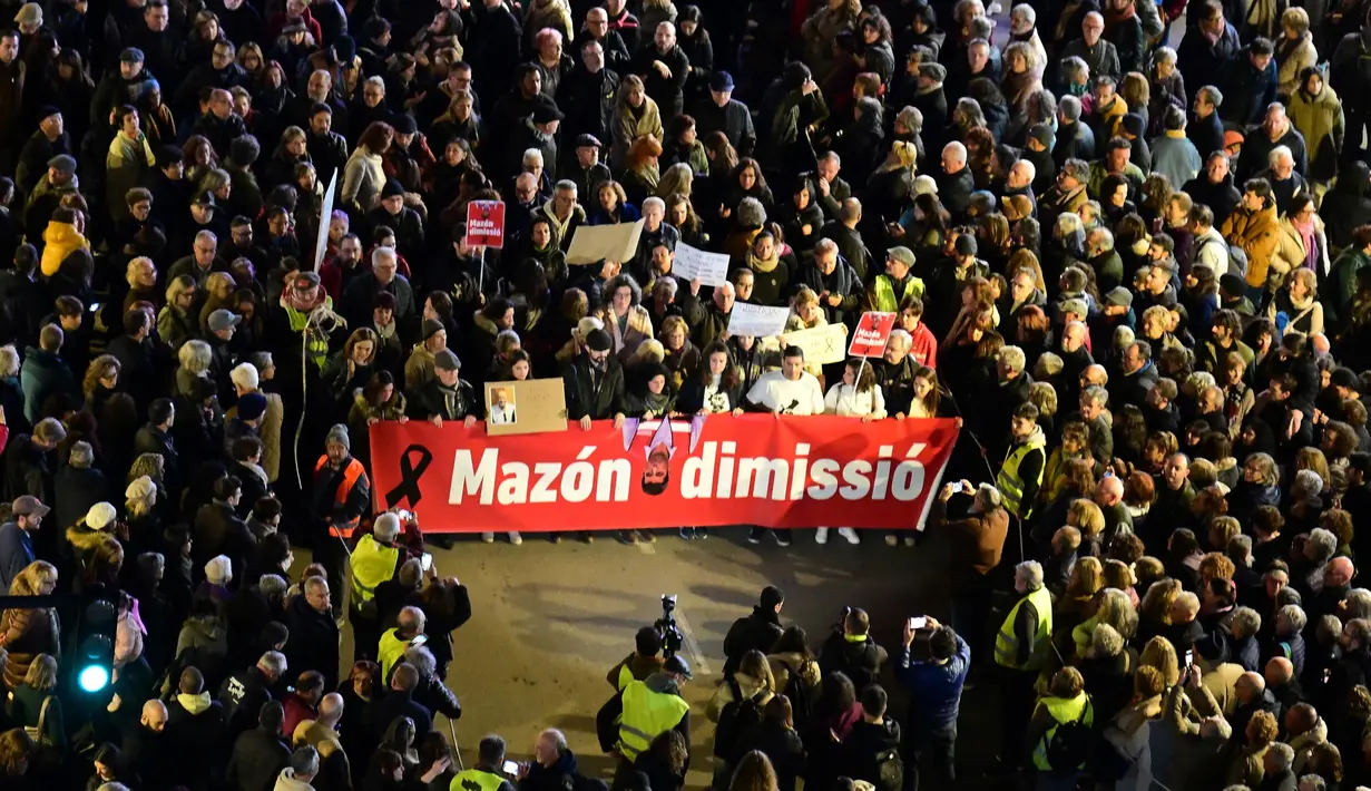 Para pengunjuk rasa memegang spanduk bertuliskan 'Carlos Mazon, Mundur' saat menuntut pengunduran diri presiden regional Valencia pada Minggu 29 Desember 2024. (JOSE JORDAN/AFP)
