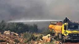 Para petugas pemadam kebakaran menyemprotkan air untuk memadamkan api di wilayah pedesaan di Provinsi Hama, Suriah tengah, pada 9 September 2020. Api melalap tanah pertanian di wilayah pedesaan provinsi tersebut, papar seorang pejabat Suriah pada Rabu (9/9). (Xinhua/Stringer)