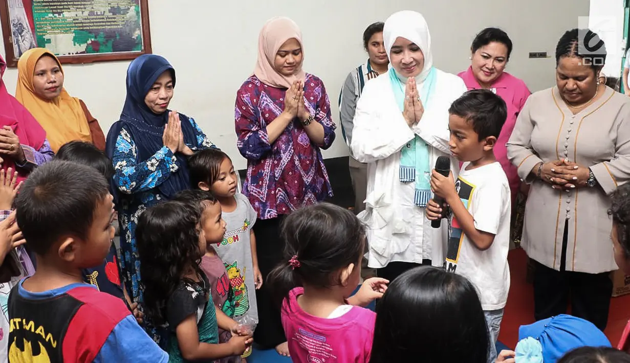 Ketum Bhayangkari, Tri Suswati Tito Karnavian mendengarkan cerita anak-anak korban bencana banjir Sentani di Kabupaten Jayapura, Papua, Jumat (22/3). Pada kesempatan itu Tri Tito dan Polwan melakukan trauma healing. (Liputan6.com/Pool/Humas Mabes Polri)