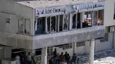 Orang-orang berkumpul di pintu masuk Rumah Sakit Jabal Amel yang rusak, setelah serangan udara Israel pada Senin (1/6) yang menghantam gedung di dekatnya, di kota pelabuhan selatan Tyre, Lebanon, Selasa 2 Juni 2026. (AP Photo/Mohammed Zaatari)