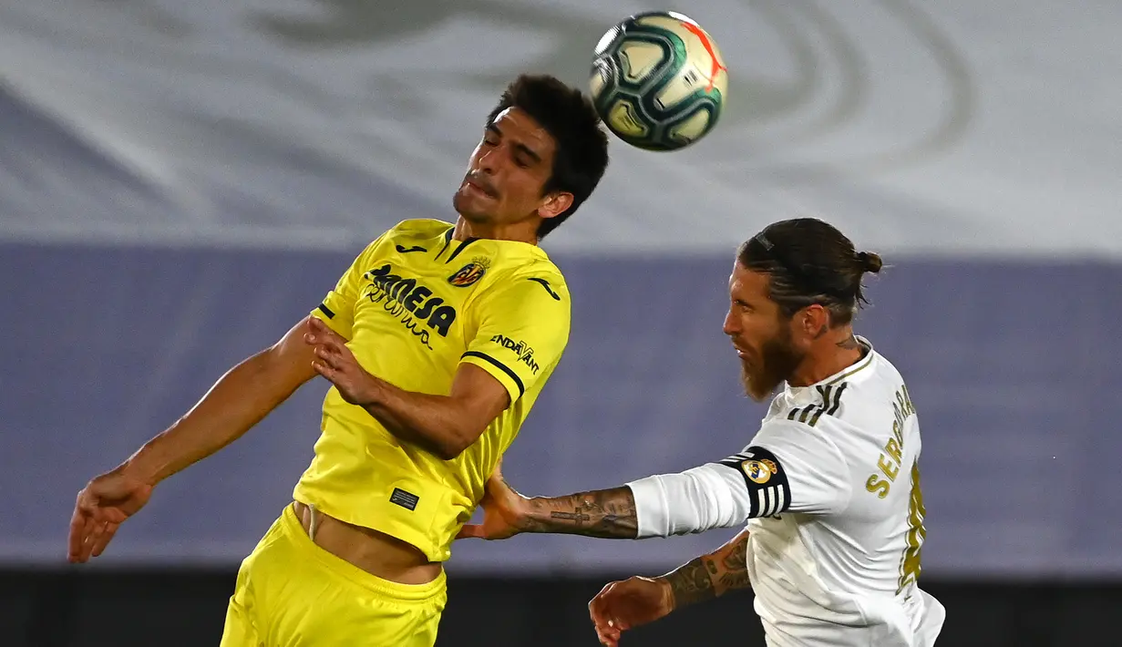 Bek Real Madrid, Sergio Ramos (kanan) berebut bola dengan pemain depan Villarreal, Gerard Moreno pada lanjutan kompetisi Liga Spanyol di Estadio Alfredo Di Stefano, Kamis (16/7/2020). Real Madrid memastikan diri menjadi juara La Liga musim 2019/20 usai mengalahkan Villarreal 2-1. (GABRIEL BOUYS/AFP)
